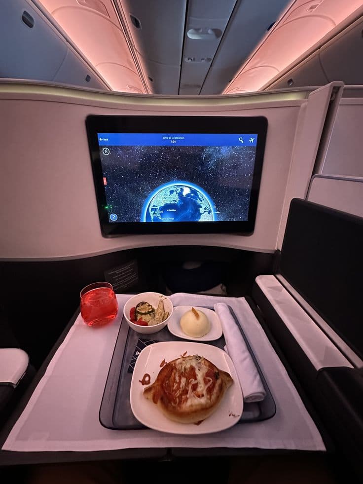 Passenger dining in a Delta One business class suite, part of the Delta One vs United Polaris comparison