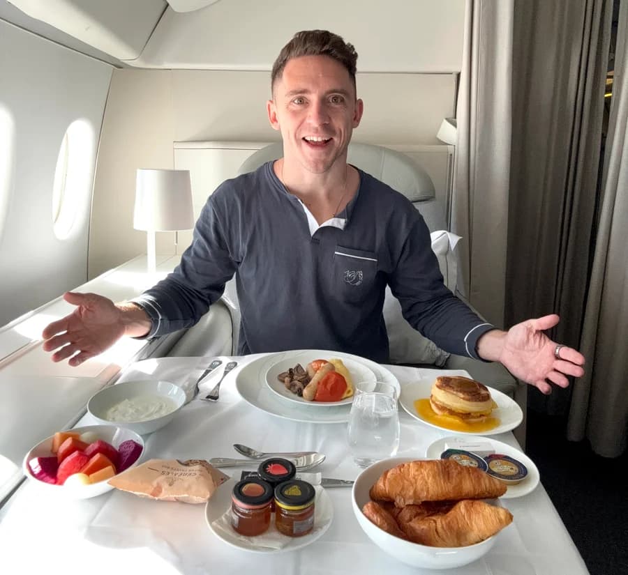 Traveler enjoying breakfast in a premium cabin after an upgrade to business class