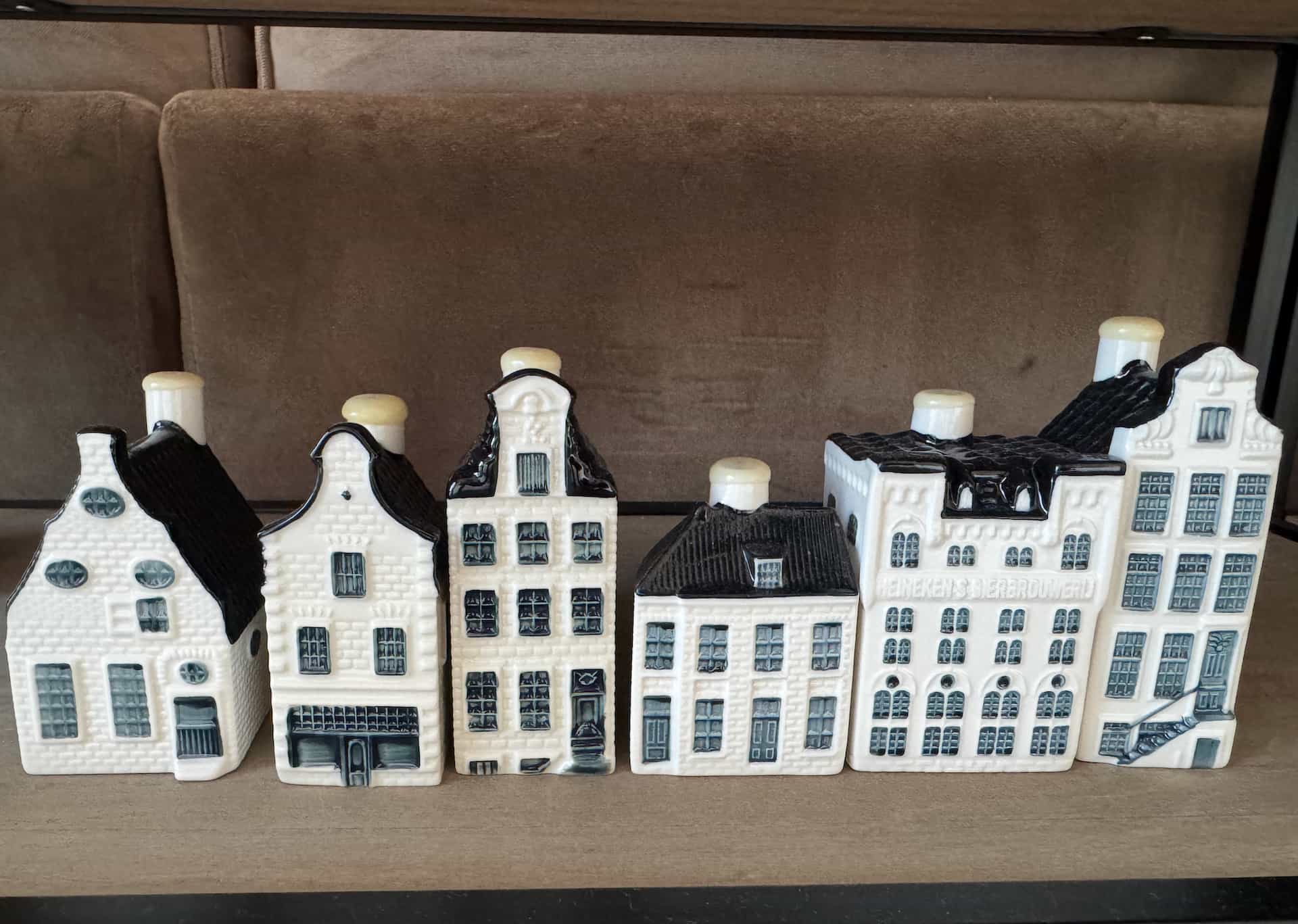 Six KLM Delft Blue miniature houses from a personal collection lined up on a shelf